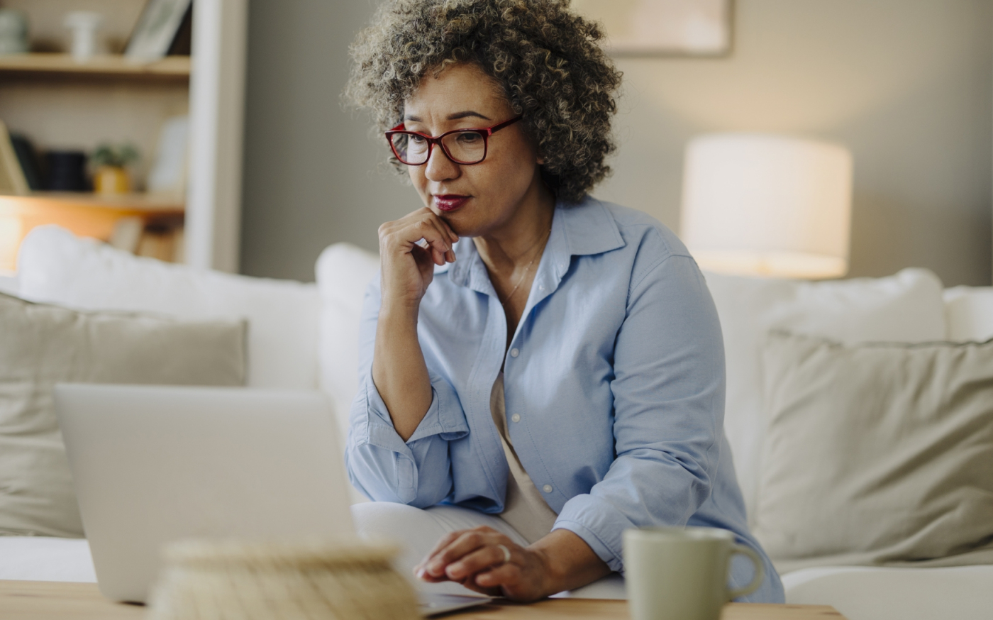 Femme réfléchissant tout en utilisant un ordinateur portable